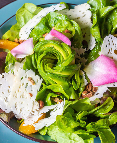 ensalada de lechuga, palta, gajos de naranjas, almendras tostadas, queso de cabra marinado con emulsión de sésamo