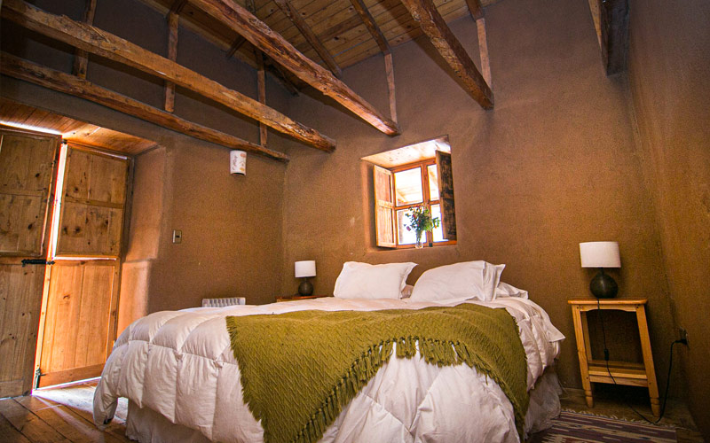 habitacion de hotel rustico con cama matrimonial