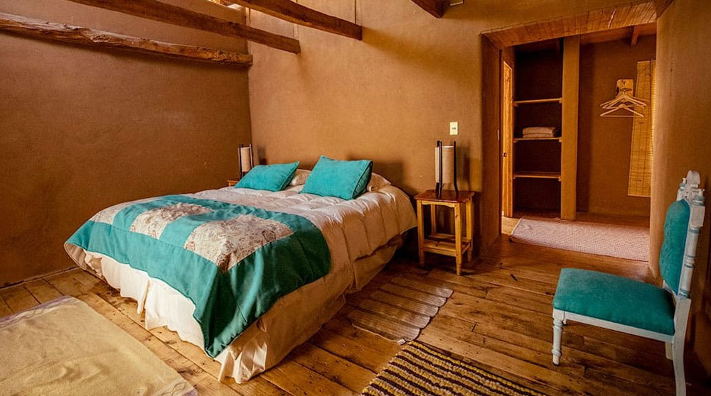 habitacion de hotel rustico con cama matrimonial